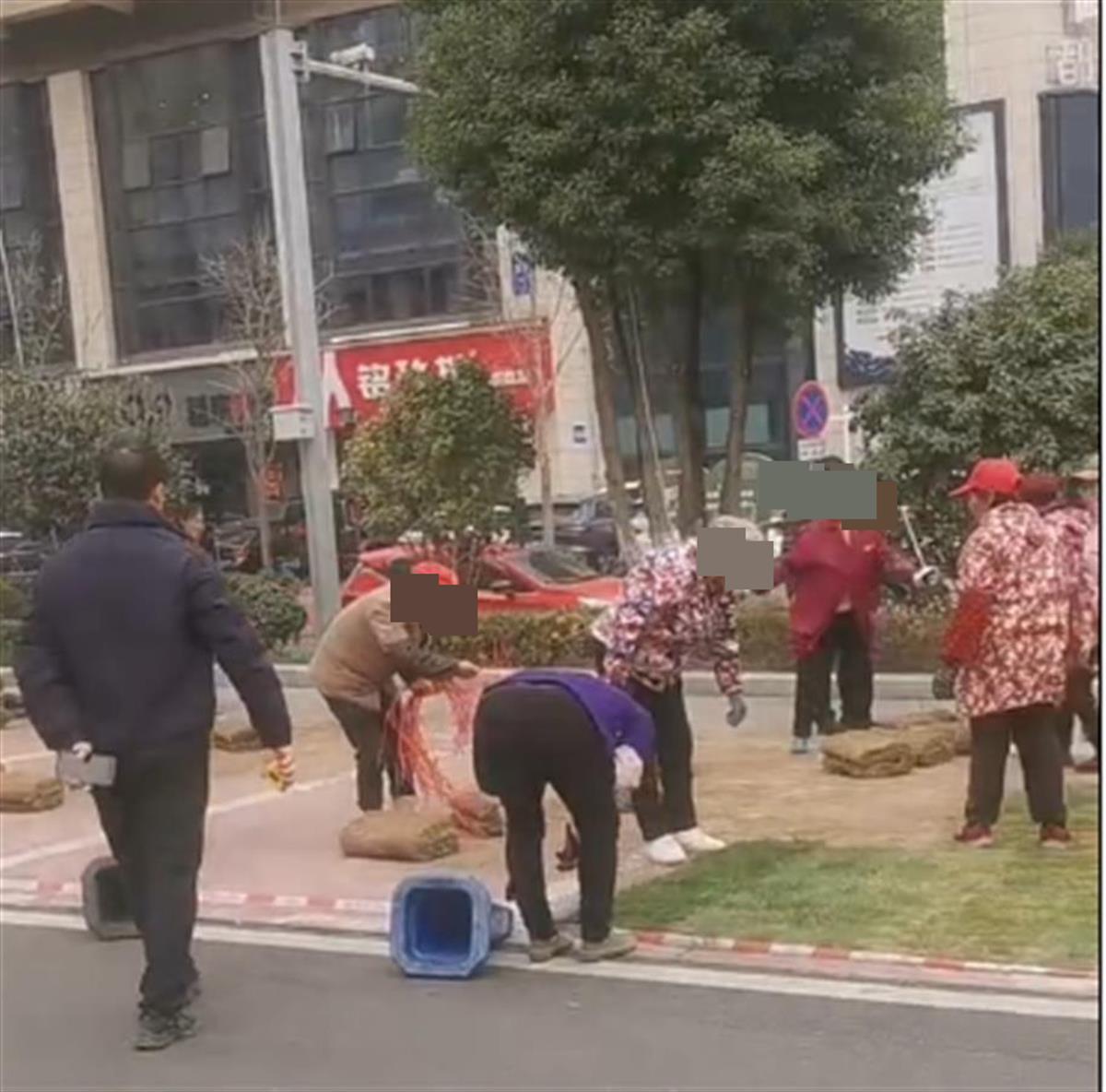 湖南一小区有人在水泥地上铺设草坪？当地：酒店为庆祝开业布置的，并非绿化率不够